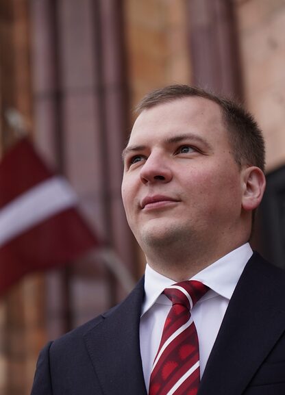 Владимир Иванов на фоне флага Латвии